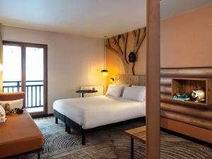 una camera con letto e balcone di ibis Styles Les Houches Chamonix a Les Houches