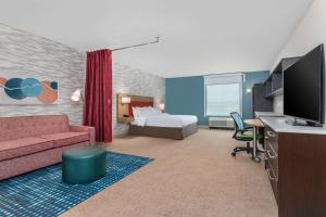 Habitación de hotel con sofá y cama en Home2 Suites By Hilton Cedar Rapids Westdale en Cedar Rapids