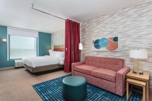 een hotelkamer met een bed en een bank bij Home2 Suites By Hilton Cedar Rapids Westdale in Cedar Rapids