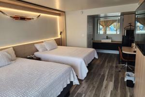 um quarto de hotel com duas camas e uma secretária em The Hotel Pendleton, Trademark Collection by Wyndham em Pendleton