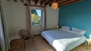 ein Schlafzimmer mit einem großen Bett und einem Fenster in der Unterkunft Chambre d'hôte en Gîte - Moulin de la Houssaie - Brocéliande in Guer