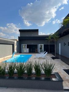 a house with a swimming pool in the yard at Recanto dos três Amores in Olímpia