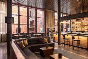ein Restaurant mit Sofa und Bar in der Unterkunft The Bankers Alley Hotel Nashville, Tapestry Collection by Hilton in Nashville