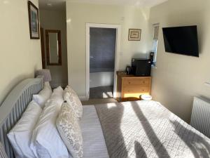 a bedroom with a bed and a television in it at Sunny Nest in Bourton on the Water