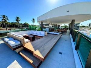 a balcony of a house with a couch and a table at Makia Beach Experience By All in Porto De Galinhas