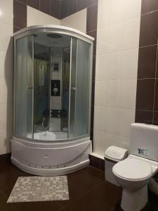 a bathroom with a shower and a toilet at Viktoria Hotel in Obroshino