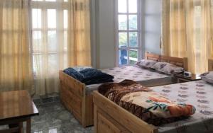 2 camas en una habitación con ventanas en Nardelna Homestay by StayApart, en Māngwa