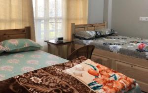 a bedroom with two beds and a table with an umbrella at Nardelna Homestay by StayApart in Māngwa +10 photos