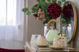 a table with a mirror and a tea pot and flowers at Urban Rooms B&R in Málaga