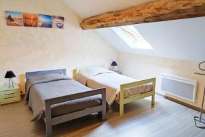 a bedroom with two beds in a attic at Maison de campagne au calme entre Vézelay Avallon in Domecy-sur-le-Vault