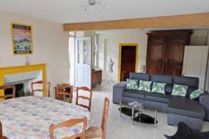 a living room with a blue couch and a bed at Maison de campagne au calme entre Vézelay Avallon in Domecy-sur-le-Vault