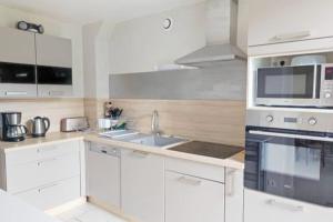 a white kitchen with a sink and a microwave at Maison de campagne au calme entre Vézelay Avallon in Domecy-sur-le-Vault +10 photos