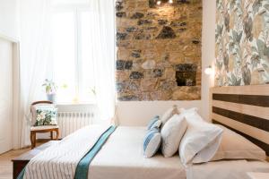 una camera da letto con un muro in pietra e un letto con cuscini di The Railway 74 a La Spezia