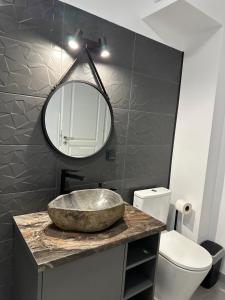 a bathroom with a stone sink and a mirror at Apartament Bonton Predeal in Predeal