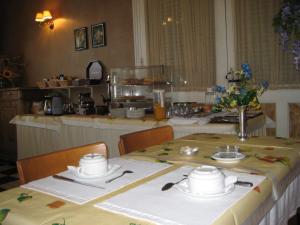 una mesa con sillas y una cocina en una habitación en Hotel Bellevue de tradition familiale, en Morcenx