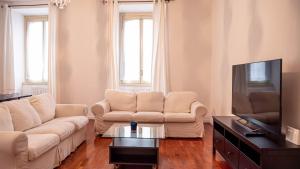 a living room with a couch and a tv at APPARTAMENTO Superhouse PIAZZA DUOMO AREA in Milan
