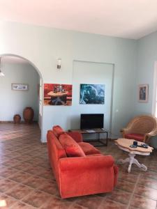 uma sala de estar com um sofá vermelho e uma mesa em Villa Il Paradiso Andros em Gavrio