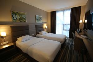 una camera d'albergo con due letti e una televisione di Hotel Excellence Inn a Ankara
