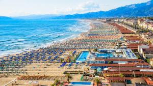 een luchtzicht op een strand met parasols en de oceaan bij PFA Hotel Viareggio in Viareggio