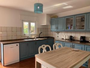 a kitchen with blue cabinets and a wooden table at Quinta Samor in Aljezur