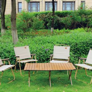three lawn chairs and a bench in the grass at The Yun Hotel Foshan Nanhai in Foshan