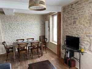 una sala da pranzo con tavolo e sedie di Appartement 3 Pièces Bord de mer Place du 6 Juin ad Arromanches-les-Bains