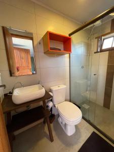 a bathroom with a toilet and a sink and a shower at Moçamba LODGE Contêiner in Florianópolis