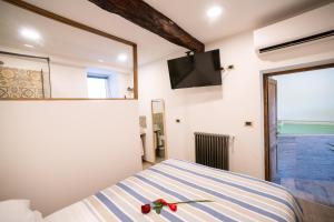 a bedroom with a bed and a tv on the wall at Podere Maletto - Appartamento con PISCINA INTERNA riscaldata Savona in Savona