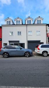 two cars parked in a parking lot in front of a building at Double Bedroom with private bathroom and shared kitchen in Oldbury