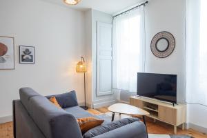 a living room with a couch and a tv at Le Cosy magnifique T2 neuf Centre ville Gare 800 m in Agen