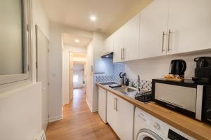 a kitchen with white cabinets and a sink at Le Cosy magnifique T2 neuf Centre ville Gare 800 m in Agen