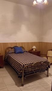 um quarto com uma cama com uma almofada azul em Casa Custodia em Mota del Cuervo