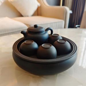 a tray with three tea pots on a table at The Yun Hotel Foshan Nanhai in Foshan