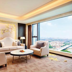 uma sala de estar com duas cadeiras e uma grande janela em The Yun Hotel Foshan Nanhai em Foshan