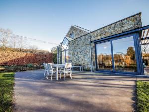 a table and chairs in front of a stone building at Maison Le Saint Pierre with lots of charm in Modave