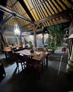 ein Esszimmer mit einem Holztisch und Stühlen in der Unterkunft Nirvana Pension in Ubud
