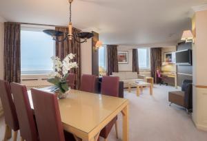 a dining room and living room with a table and chairs at Grand Hotel Blackpool in Blackpool