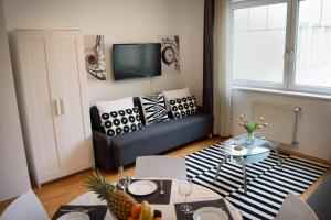 een woonkamer met een bank en een tafel bij Peony Káldy Apartman Free Garage under the house in Boedapest