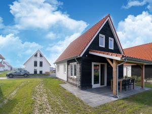 une maison noire avec un toit orange dans l'établissement Luxurious holiday home with garden and parking, à Scherpenisse