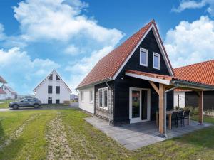 a black house with an orange roof at Luxurious holiday home with parking in Scherpenisse