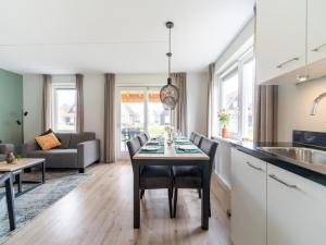 Il comprend une cuisine et un salon avec une table et des chaises. dans l'établissement Luxurious holiday home with garden and parking, à Scherpenisse