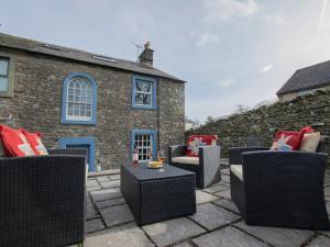 a group of chairs sitting on a patio in front of a building at 3 Bed in Shap 74159 in Shap