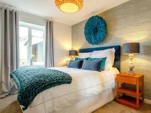 a bedroom with a large bed with blue pillows at 4 Bed in Westward Ho 66659 in Northam