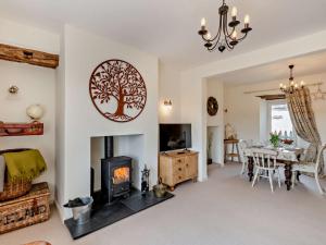 a living room with a fireplace with a tree on the wall at 2 Bed in Grange Over Sands 73544 in Grange Over Sands