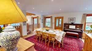 a dining room with a table and a piano at Carriden in Insh