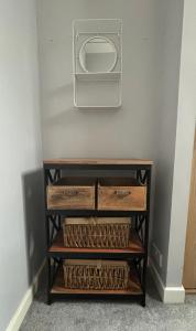 a shelf with a microwave on a wall with baskets at County House City Centre with parking Sleeps 4 in York
