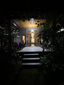un pasillo de una casa por la noche con una puerta en Nirvana Pension, en Ubud