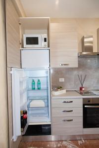 a kitchen with an open refrigerator with a microwave at Luxury house Il tramonto in Anzio