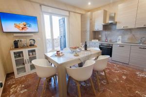 a kitchen with a table with chairs and a tv on the wall at Luxury house Il tramonto in Anzio