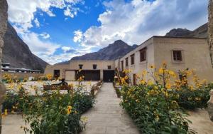 a building with a bunch of flowers in front of it at Green Tara Homestay by StayApart in Tabo